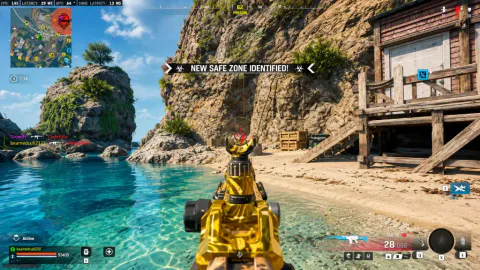 Sunny Warzone beach and cove with a gold-pattern rifle in hand and a new safe zone notification on the HUD.