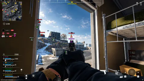 Pistol aim from a barracks window toward a highlighted enemy player marked outside near snowy terrain.